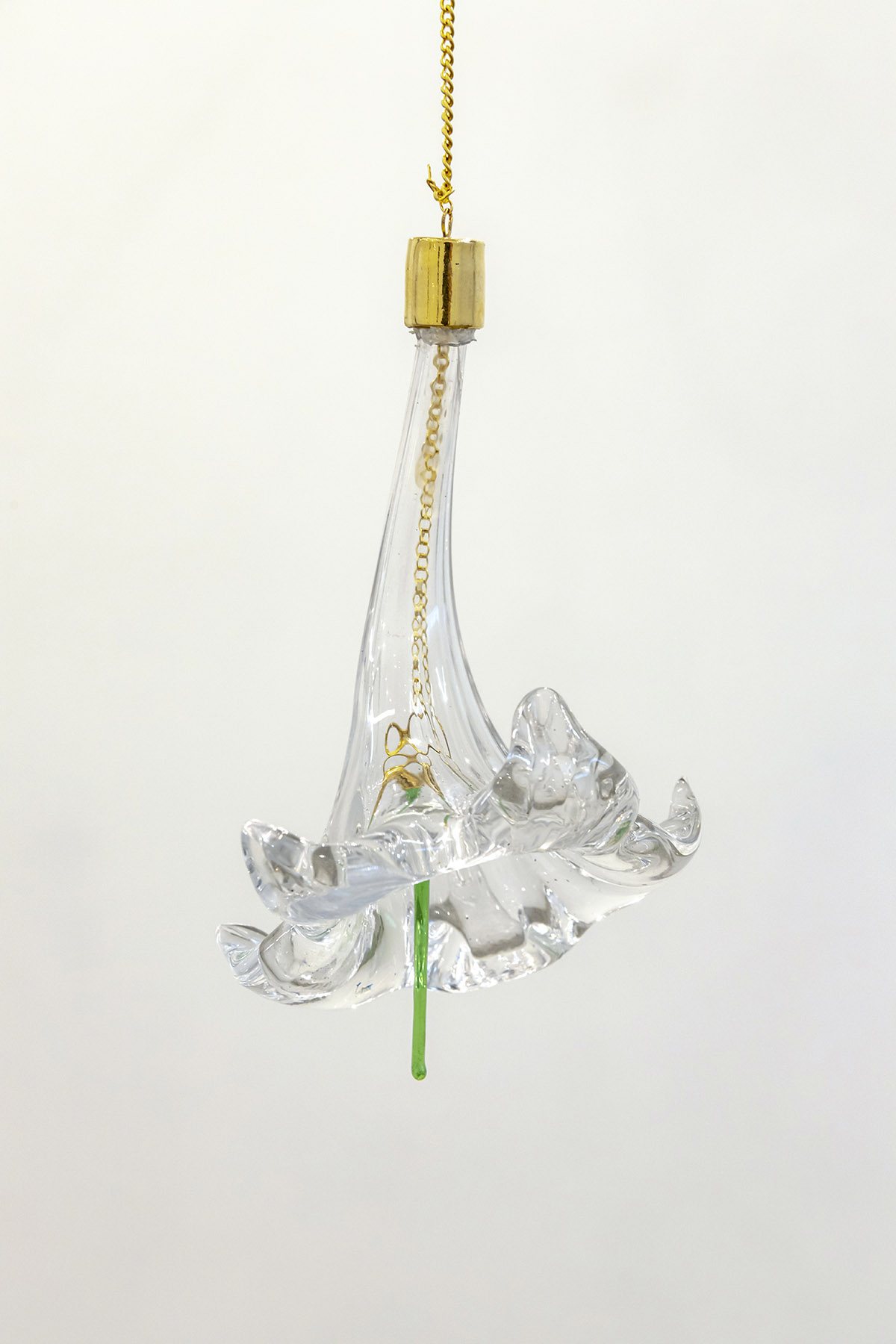 A blown glass lily trumpet hanging from a brass socket